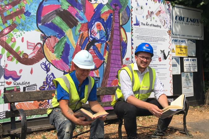 Builders sitting on bench in front of hoardings
