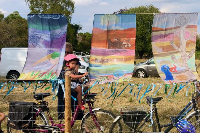 Child peering between hangings outside Leper Chapel